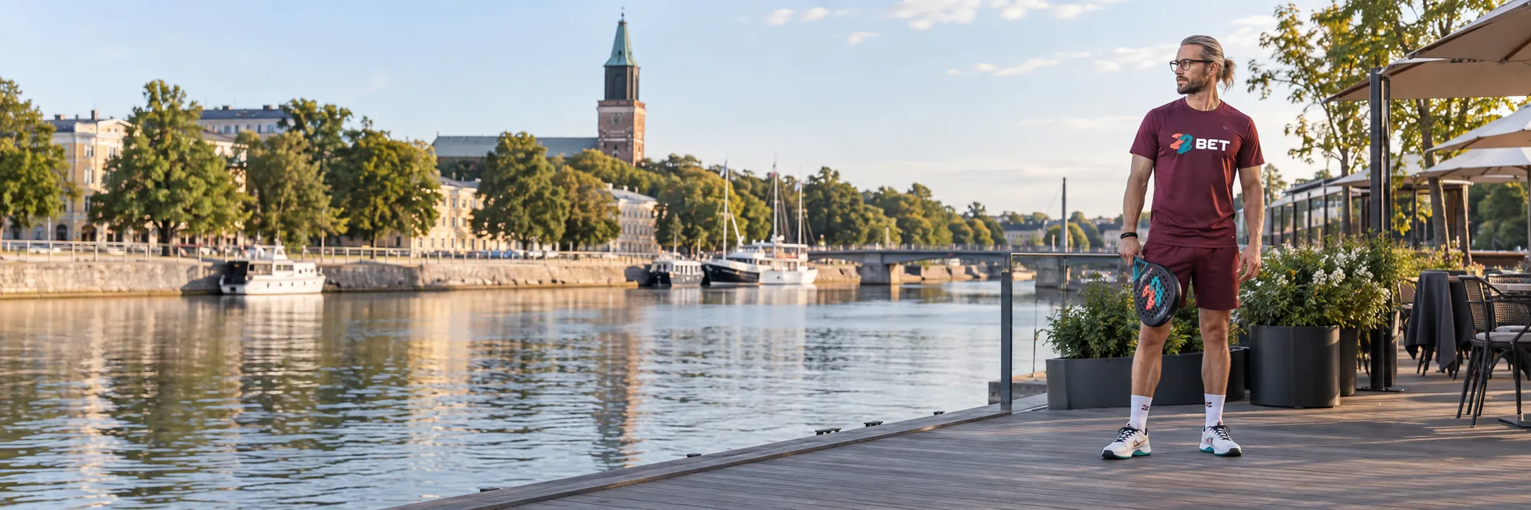 Badminton player beside the Turku waterfront wearing 22BET branding